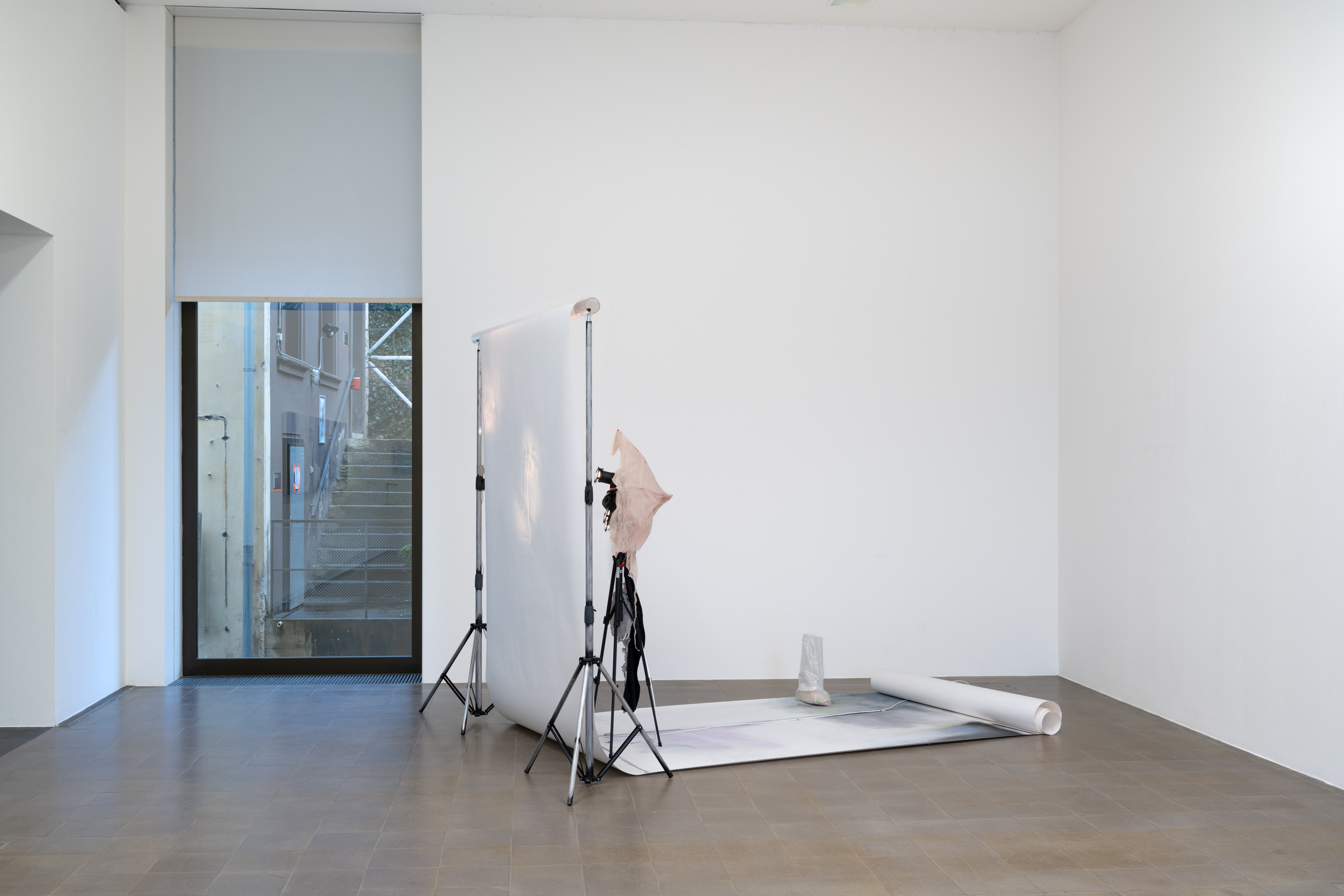 Estéfana Román Matesanz, *A Flick to Stop the Ball in Mid-Flight*, 2025/26. Tripod, umbrella, clothing, wax
and fabric, pastels, charcoal and pencil, spray paint on paper, Dimensions variable. Photo: Finn Curry.
